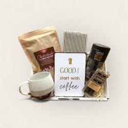 Kaffekurv med krus, servietter, skilt og godter